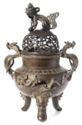 A Chinese bronze koro with cover: the domed and pierced cover surmounted by a temple dog,
