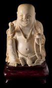 A late 19th century Chinese carved ivory figure of a seated Buddah: wearing loose robes and adorned