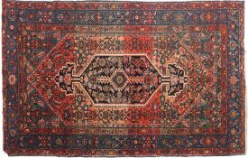 A Hamadan rug:, the shaped rose field with an indigo hooked hexagonal pole medallion,