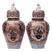 A pair of Japanese Imari porcelain jars and covers: of lobed oviform the domed covers with shi shi