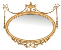 A carved giltwood and gesso oval mirror in the neo-classical taste:,