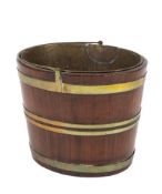 An early 19th Century mahogany and brass bound oval bucket:, with brass swing handle and liner, 35.