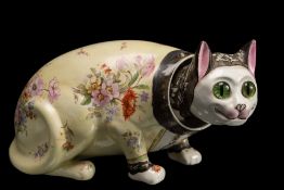 A Galle-style 'nodding' pottery cat: modelled crouching and transfer decorated with flowers on a