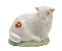 A Lowestoft model of a reclining ewe: of small size, with iron red markings, on green mound base,
