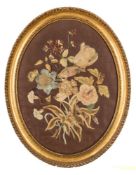 A 19th Century oval silkwork panel: depicting a bird amongst flowers,