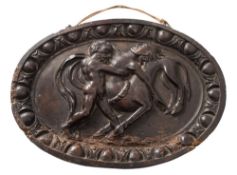 A 17th/18th Century carved walnut oval plaque: depicting Herakles attacking a centaur within an egg