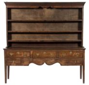 A late 18th/early 19th Century oak dresser:, the shelved superstructure with a moulded cornice,