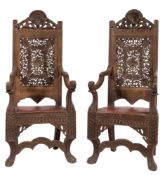 A pair of 19th Century Indian carved hardwood open armchairs:,