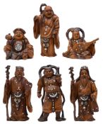 A group of six Japanese carved boxwood figures of the Gods of Fortune: each stained and inlaid with
