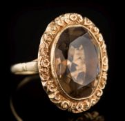 A 9ct gold and smoky quartz single-stone dress ring: the oval smoky quartz approximately 19.