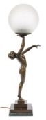 An Art Deco period bronzed metal lamp in the form of a semi naked female gymnast: standing with her
