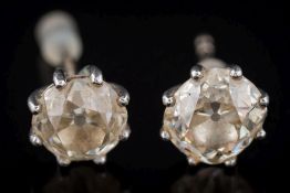 A matched pair of diamond single-stone ear studs: each with a round old brilliant-cut diamond