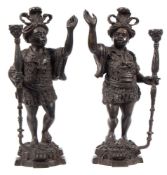 A pair of bronze patinated standing blackamoor figures: wearing traditional dress,