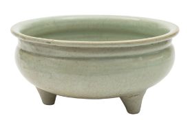 A Chinese celadon glazed censer: of typical squat circular form set on three peg feet,