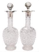 A pair of George V clear glass and silver mounted decanters and stoppers,