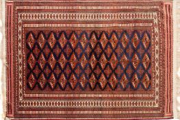 A Turkoman rug:, the indigo field with an all over design of quartered lozenge medallions,