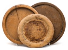 A Swedish beechwood platter and two other platters: the first carved to the base with the initials
