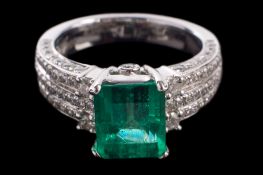 A platinum, emerald and diamond ring: the octagonal-cut emerald approximately 8.7mm long x 7.