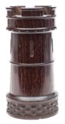 A treen carved lignum vitae spill vase: in the form of a castellated turret, 16 cm high.