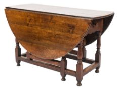 An 18th Century oak oval gateleg table:, with a hinged top,