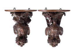 A pair of carved oak brackets: in the form of birds with partially outstretched wings,
