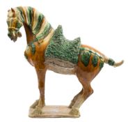 A Chinese pottery model of a caparisoned Fereghan horse: decorated in sancai glazes,