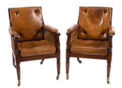 A pair of mahogany library bergere armchairs in the Regency taste:,