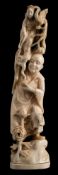 A Japanese carved ivory okimono of a man evoking a goddess: standing on a rocky outcrop,
