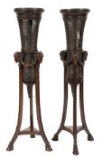 A pair of carved walnut and cane panelled torcheres:,