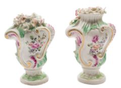 A pair of Derby pedestal vases: of rococo bombe form, each moulded with scrollwork,