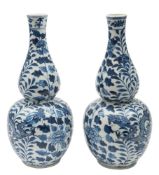 A pair of Chinese porcelain double gourd vases: painted in blue with a pair of dragons amongst