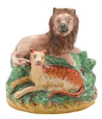 Two Staffordshire pottery figures: the first of a lion and tiger on grassy mound base, circa 1880,