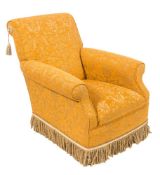 An armchair upholstered in Chanee Lecroc fabric,: gold coloured ground with foliate designs,