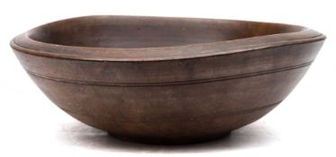 A 19th century sycamore treen dairy bowl: the exterior with double ring bands and raised foot rim,