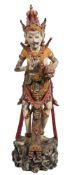 A carved wood and polychrome decorated figure of a Balinese dancer: wearing traditional costume and