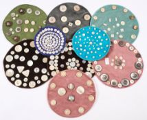 A collection of mother of pearl buttons:, mounted on nine dralon velvet circular mats.