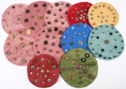 A collection of various buttons: mounted on eleven mats.