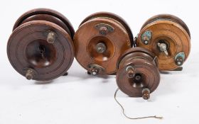 A group of four mahogany and brass star backed reels:, the largest 5 inches in diameter,