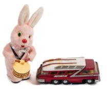 A Duracell battery operated pink drumming rabbit :and a Chinese battery operated tinplate touring
