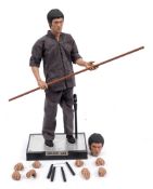 An Enterbay 1/4th scale figure of Bruce Lee:, with staff, nunchaku,