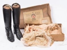 A pair of black leather riding boots with beech trees:,