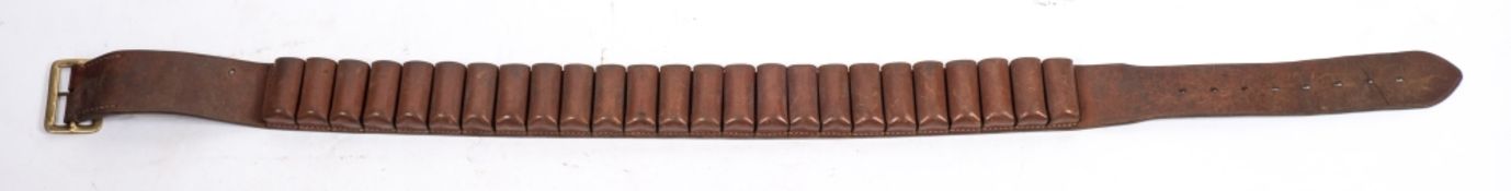 A brown leather twelve bore cartridge belt:, unsigned, with brass buckle.