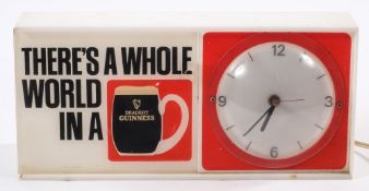 A Guinness 'There's a Whole World In Draught Guinness' clock:, 14.5 x 31.5cm.