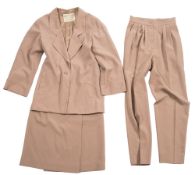 A Jaeger two piece polychrome print jacket and skirt:, together with a three piece beige jacket,