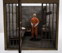A Damtoys 1/6th scale Gangsters Kingdom figure 'Saxon':, in a scale diorama prison cell,
