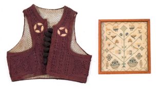 A Yugoslavian embroidered waistcoat with geometric decoration together with a framed needlework,