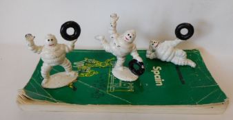 Three cast metal and painted Michelin advertising figures: and Michelin Spanish guide book.