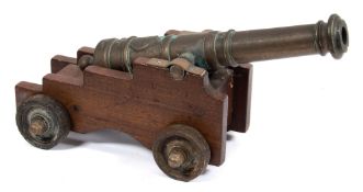 A brass and mahogany model of a cannon on a Royal Navy pattern truck with iron wheels:, 46cm long.