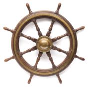 A teak and brass ship's helm:, unsigned the central iron hub with dome brass boss,