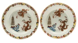 A pair of Chinese famille rose plates: each painted with a dragon chasing a flaming pearl,